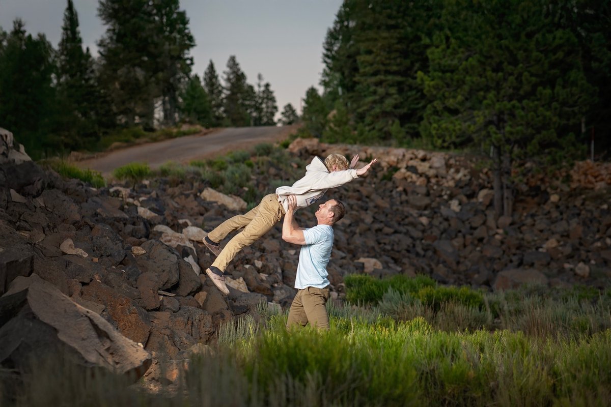 Dad lifting his son in the air outdoors